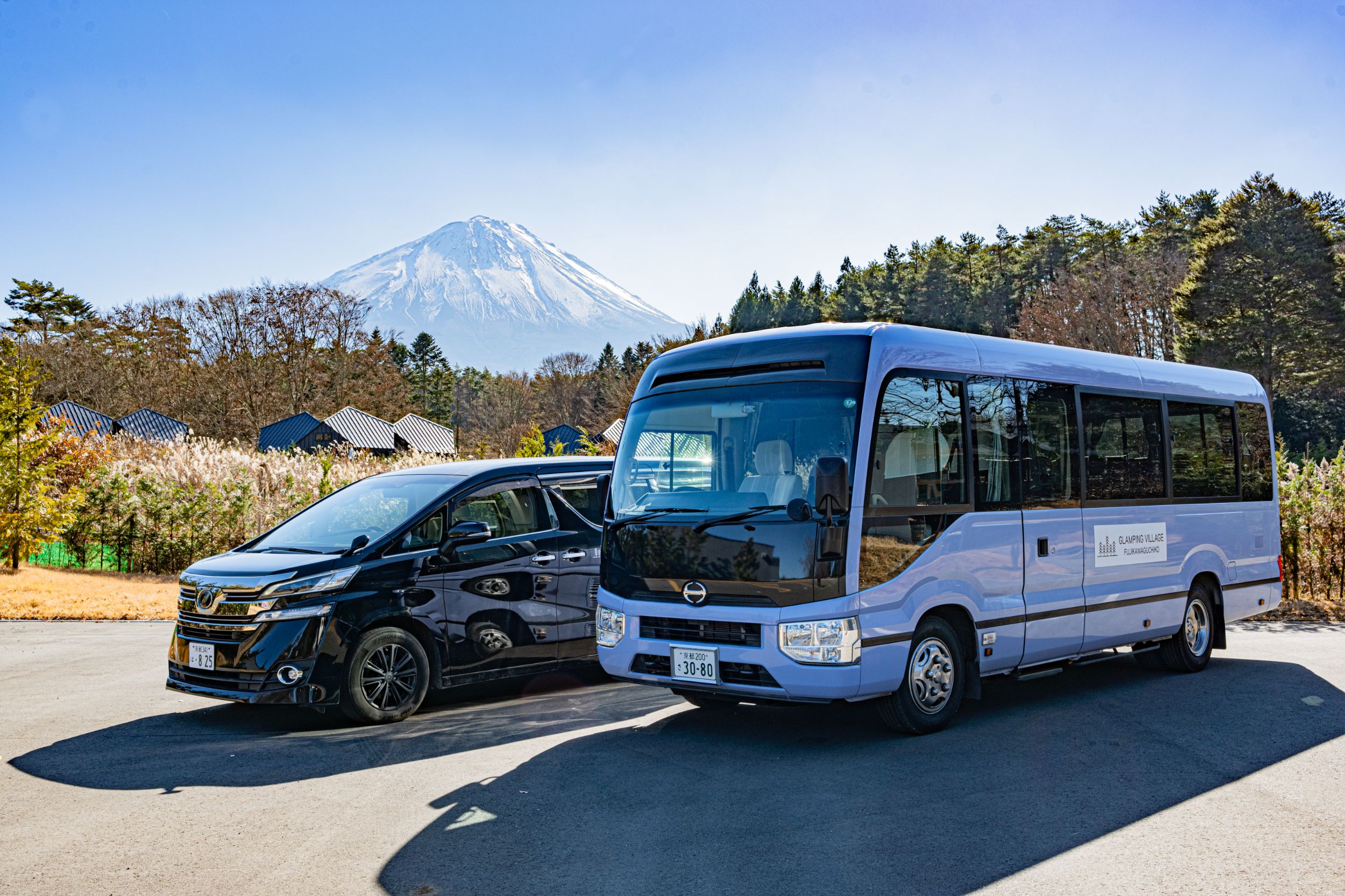 以富士山為背景並排的接送休旅車與中巴